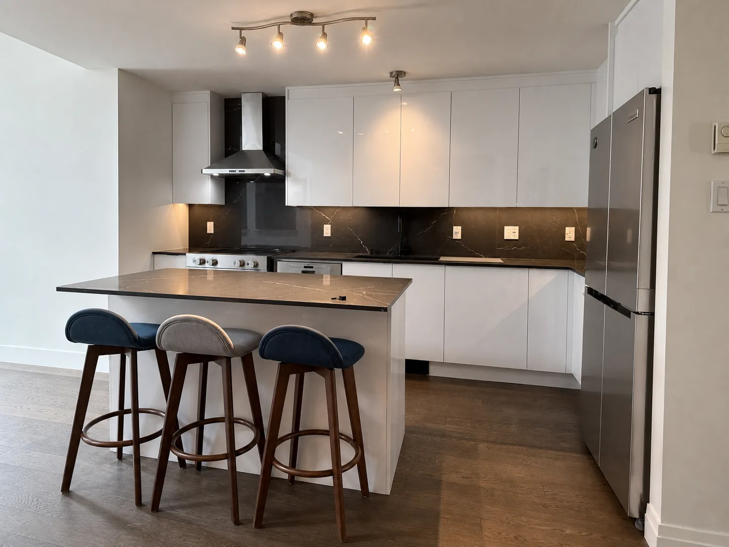 Handleless high gloss white kitchen with black quartz island in Pierrefonds, by Limakdéco